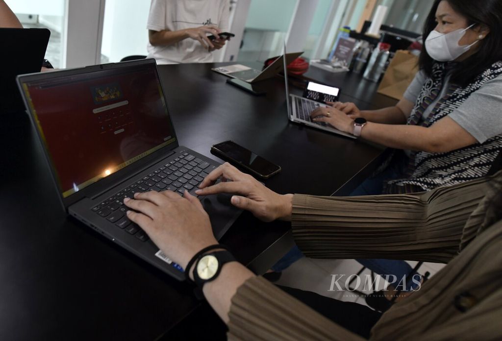 Salah seorang karyawan membuka komputer jinjing saat mengikuti pertemuan di ruang kerja bersama (<i>coworking space</i>) Impact Hub di kawasan Setiabudi, Jakarta Selatan, Kamis (25/11/2021). 