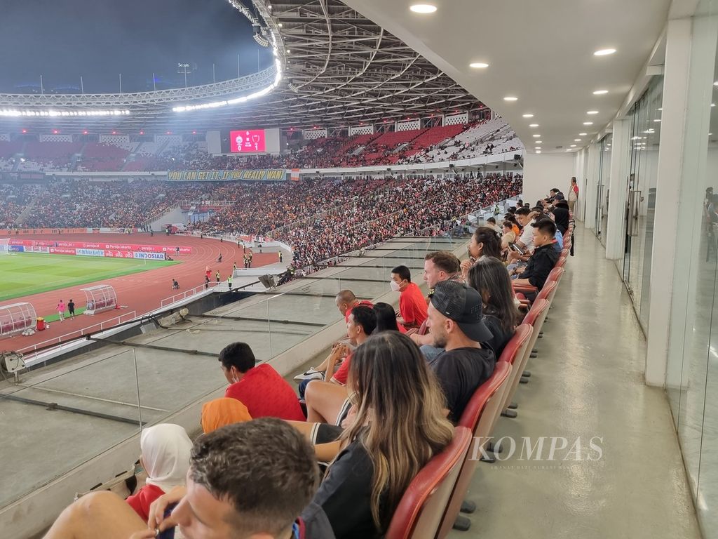 Pemandangan ke arah sisi selatan dari tribune <i>lounge</i> Stadion Utama Gelora Bung Karno, Jakarta, pada laga Persija Jakarta melawan PSM Makassar, Senin (3/7/2023) malam. Terlihat penyerang asing Persija, Marko Simic (mengenakan topi hitam), menyaksikan gim itu.