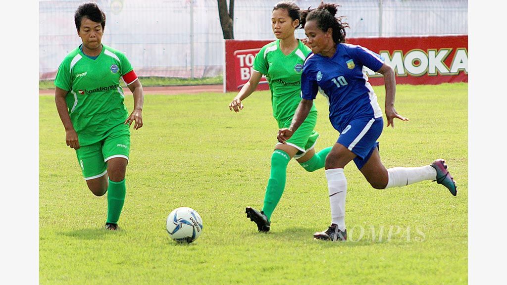 Pesepak bola putri Papua, Yudith Herlinda Sada (kanan), menggiring bola   melewati pemain Banten dalam kejuaraan Piala Pertiwi di Stadion Atletik Jakabaring, Palembang, Sabtu (9/12). Tim putri Papua menang 2-0. Ajang ini menjadi uji coba kejuaraan Asian Games  2018.