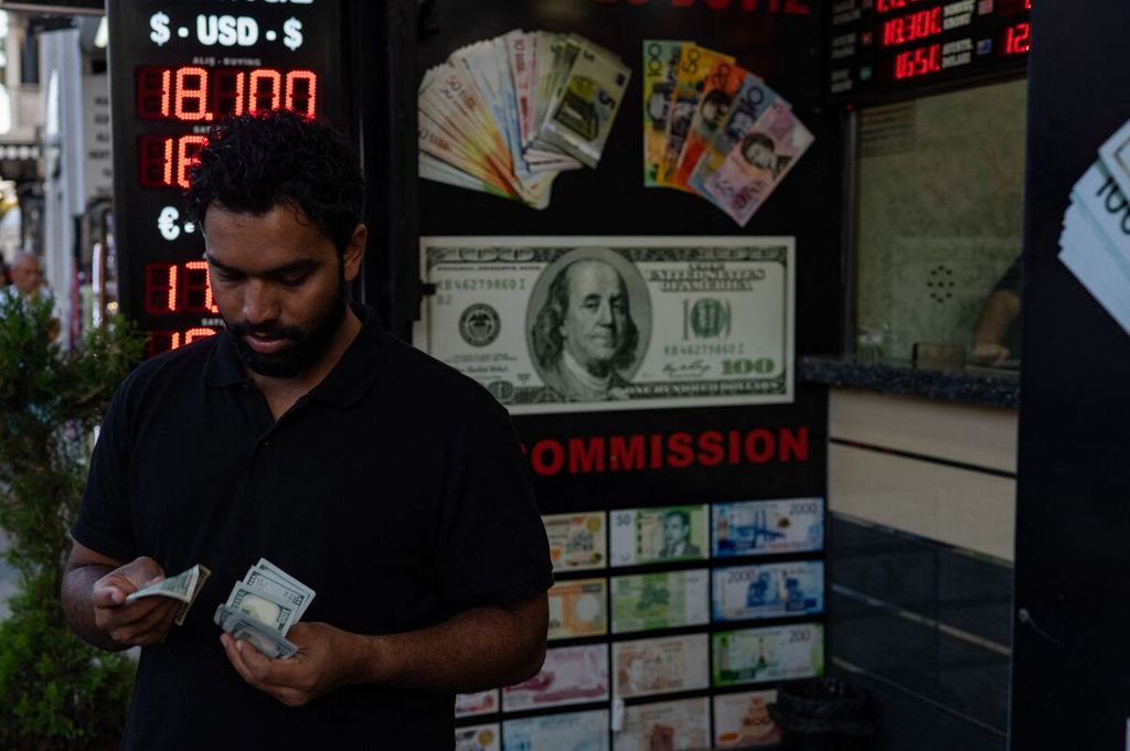 Seorang warga tengah menghitung mata uang dollar di luar sebuah tempat penukaran mata uang di Istanbul, Selasa (6/9/2022). 