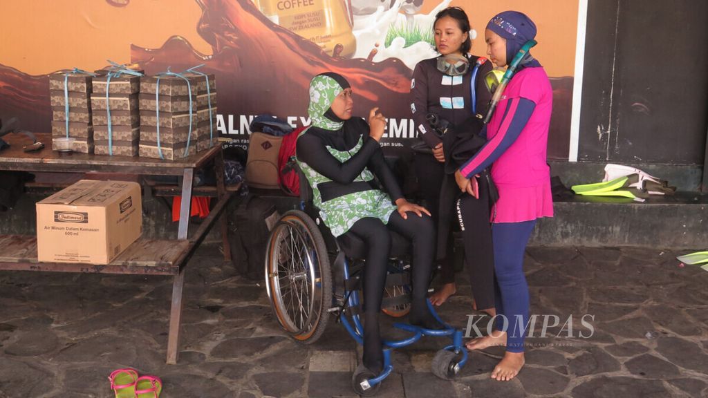 Sri Lestari (45), penyandang disabilitas paraplegia (lumpuh separuh tubuh bagian bawah), berbincang dengan sejumlah penyelam saat mengikuti kegiatan pelatihan selam Diveable di mata air Umbul Ponggok, Klaten, Jawa Tengah, Kamis (20/6/2019). 