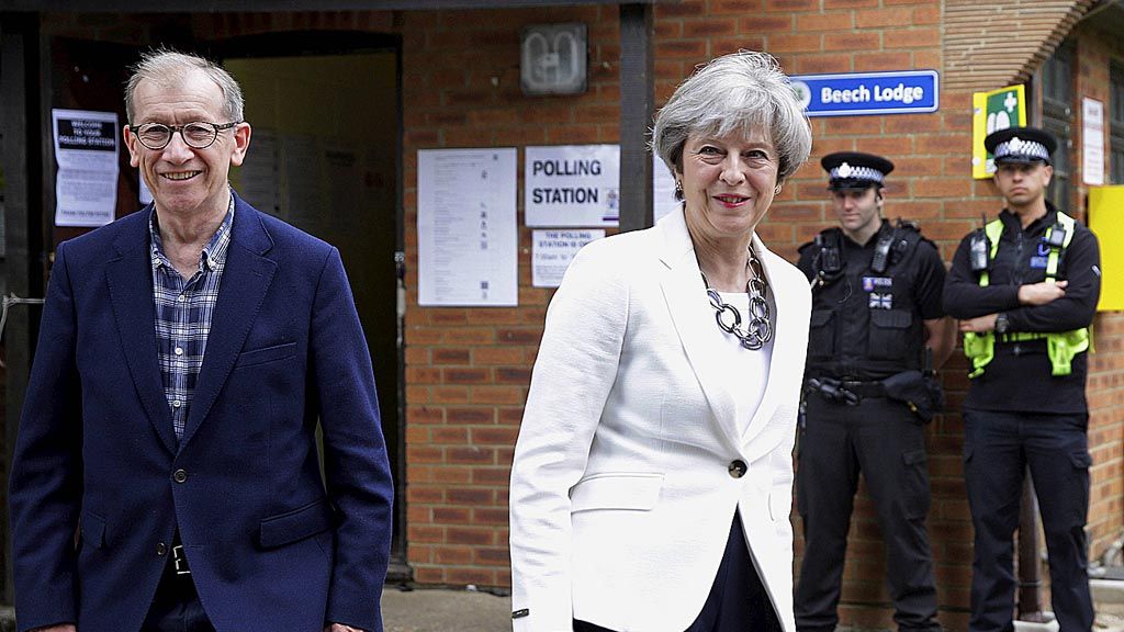 Perdana Menteri Inggris Theresa May bersama suaminya, Philip, meninggalkan tempat pemungutan suara, di Maidenhead, Inggris, Kamis (8/6), setelah memberikan suaranya di lokasi tersebut.  