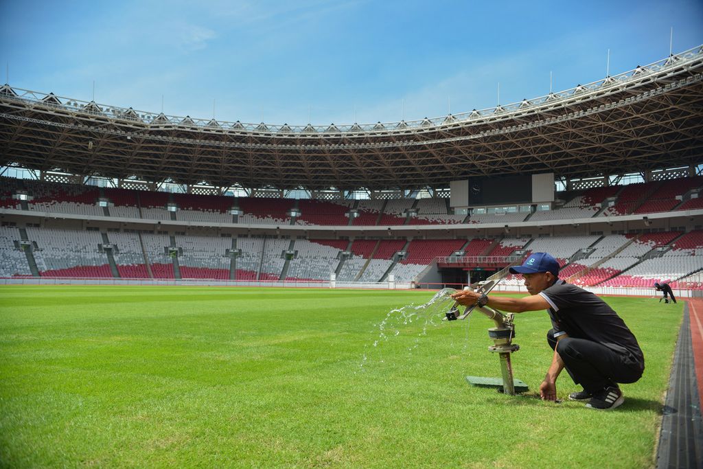 Pekerja menyiapkan <i>water gun</i> untuk membasahi rumput lapangan Stadion Utama Gelora Bung Karno, Jakarta, Kamis (6/4/2023). 
