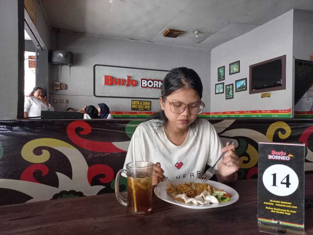 Agnes menikmati nasi <i>magelangan </i>dan segelas es teh manis di Burjo Jalan Seturan, Yogyakarta.