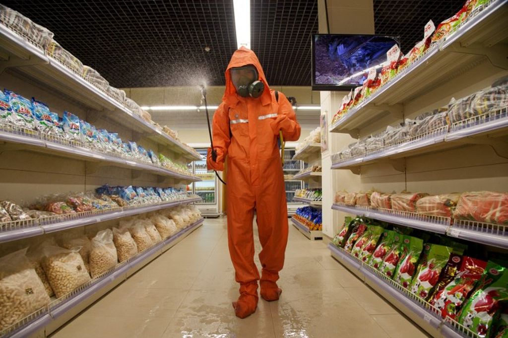 Dalam gambar yang diambil pada 27 September 2021, seorang petugas kesehatan menyemprotkan disinfektan sebagai bagian dari tindakan pencegahan terhadap Covid-19, di Daesong Department Store di Pyongyang. 