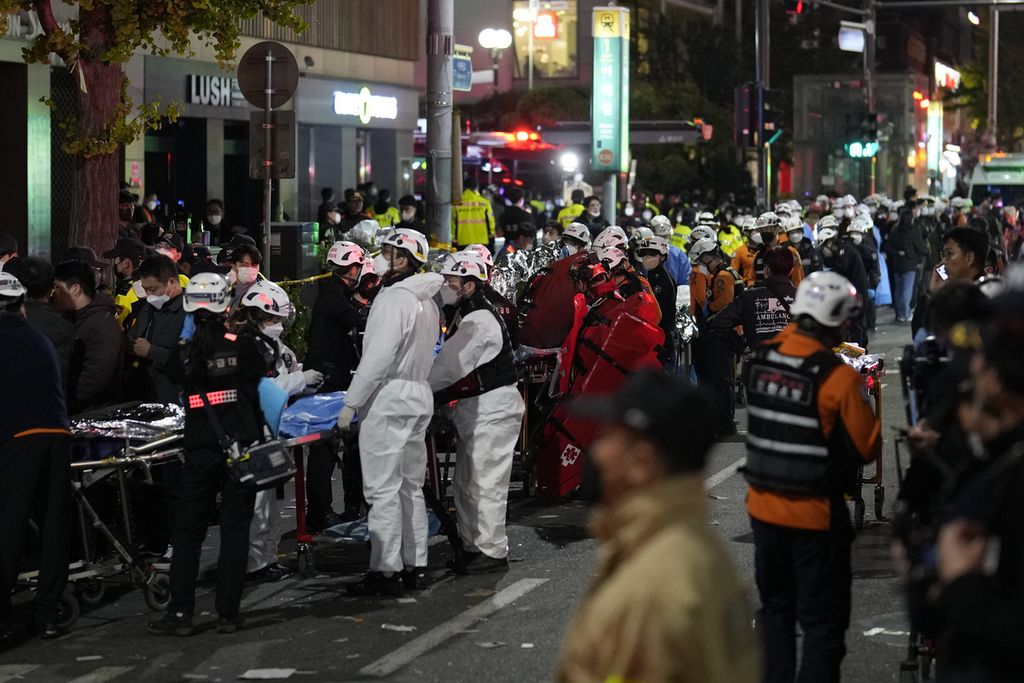  Petugas penyelamat menanti untuk mengangkut para korban dalam targedi pesta Halloween yang menewaskan lebih dari 150 orang di Seoul, Korea Selatan, Minggu (30/10/2022). 