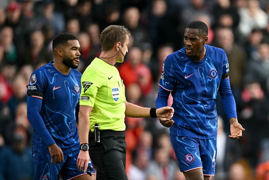 Pemain Chelsea, Tosin Adarabioyo, berbicara ke wasit John Brooks saat melawan Liverpool pada laga Liga Inggris di Stadion Anfield, Minggu (20/10/2024).