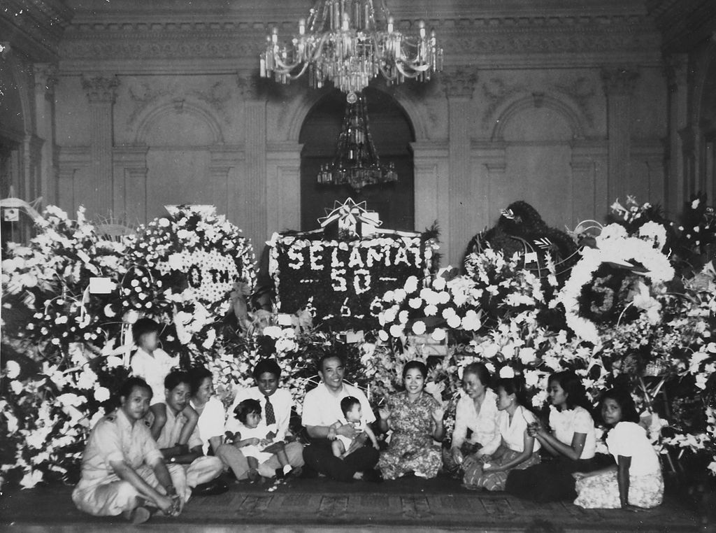 Bung Karno sekeluarga, ajudan, sekretaris pribadi, dan lain sebagainya duduk di lantai berfoto dalam peringatan hari ulang tahun ke-50 Bung Karno pada 6 Juni 1951.