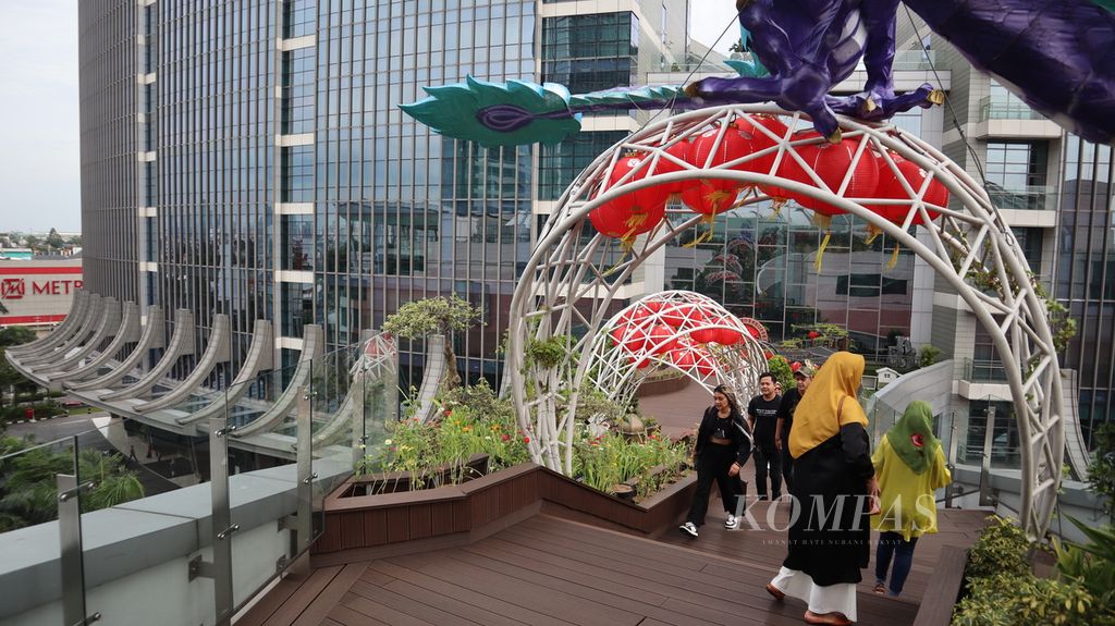 Pengunjung Pondok Indah Mall 3, Jakarta Selatan, menikmati pemandangan dari jembatan di atap gedung pusat perbelanjaan itu, Rabu (8/2/2023). Tempat bernama Love on Top itu bisa dikunjungi secara gratis.