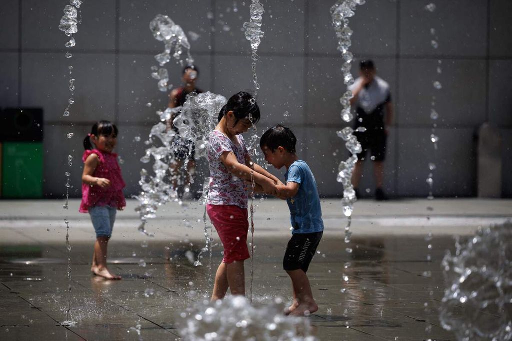 Anak-anak bermain pancuran air di tengah cuaca panas yang melanda Hong Kong, 9 Juli 2023. 