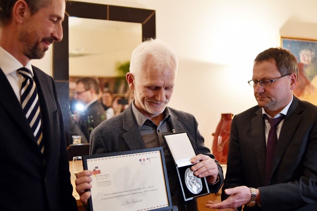 Aktivis Ales Bialiatski mendapat Anugerah HAM dan Aturan Hukum Jerman-Perancis dari Duta Besar Perancis untuk Belarus Didier Canesse (kiri) serta Dubes Jerman Manfred Huterer di Minsk, Belarus, Desember 2019. Bialiatski meraih Nobel Perdamaian 2022.