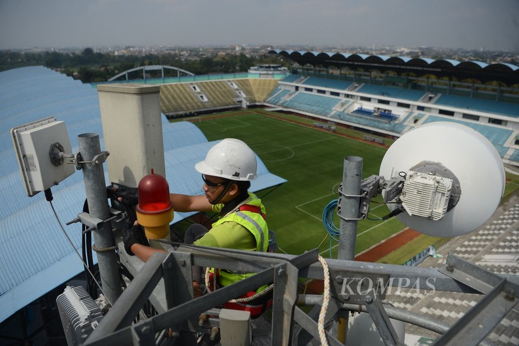 Pekerja rekanan perusahaan PT Tower Bersama Infrastructure Tbk mengecek lampu penanda menara telekomunikasi yang dikelola perusahaan tersebut di Stadion Maguwoharjo, Sleman, DI Yogyakarta, Rabu (9/10/2019). 