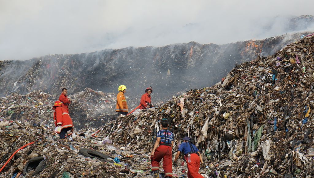 Petugas berupaya memadamkan kobaran api yang muncul pada tumpukan sampah yang menggunung, di TPA Putri Cempo, Kota Surakarta, Jawa Tengah, Sabtu (16/9/2023). Diduga, cuaca panas menjadi penyebab terjadinya kebakaran tersebut.