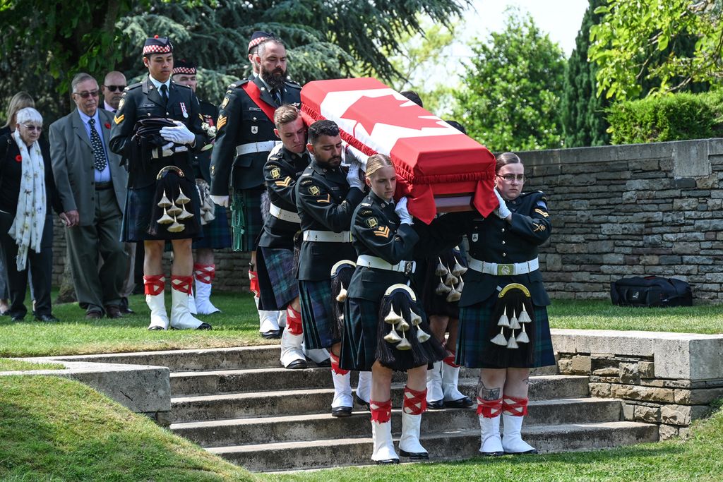 Tentara dari Dataran Tinggi Calgary Angkatan Darat Kanada membawa peti mati salah satu dari tiga tentara Kanada yang tewas dalam Perang Dunia I saat mereka dimakamkan di pemakaman militer Inggris dari Komisi Makam Perang Persemakmuran (CWGC) di Loos-en-Gohelle, dekat Lens, Perancis utara, Jumat (8/6/2023). 