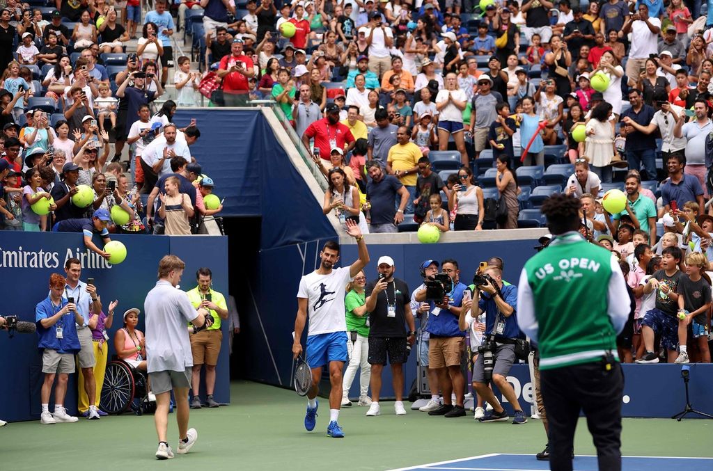 Petenis Serbia, Novak Djokovic, melambaikan tangan saat masuk lapangan pada acara Hari Anak Arthur Ashe di Pusat Tenis Nasional Billie Jean King di New York, Amerika Serikat, Sabtu (26/8/2023), yang digelar jelang Grand Slam AS Terbuka. 