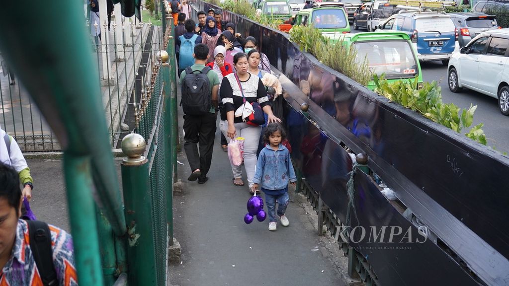 Kondisi tempat pejalan kaki di Stasiun Bogor yang dibatasi pagar stasiun dan jalan raya, Selasa (1/8). Sempitnya tempat untuk pejalan kaki di Stasiun Bogor dengan lebar 1,5 meter membuat beberapa pejalan kaki terlihat kurang nyaman karena harus berdesakan.