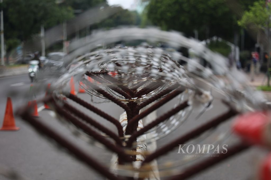 Kawat berduri dipasang di atas beton pembatas di depan Gedung Mahkamah Konstitusi, Jakarta, Minggu (21/4/2024). Menjelang pembacaan putusan perselisihan hasil pemilihan umum Pilpres 2024 pada Senin (22/4/2024), penjagaan di sekitar Gedung MK diperketat. 