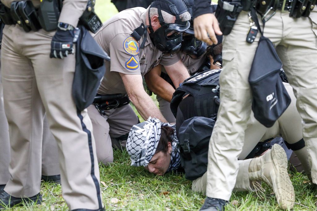 Seorang pengunjuk rasa Pro-Palestina ditangkap oleh aparat penegak hukum di Universitas South Florida MLK Plaza Fountain pada 30 April 2024 di Tampa, Florida, AS. 