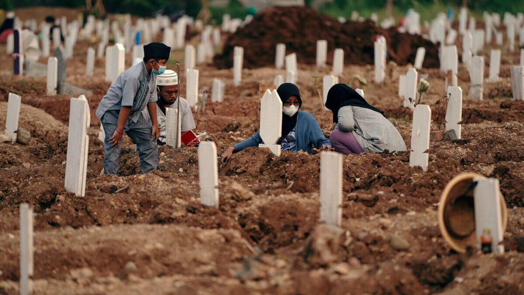 Peziarah berdoa di pusara pemakaman dengan protokol Covid-19 di Tempat Pemakaman Umum Rorotan, Kecamatan Cilincing, Jakarta Utara, Selasa (24/8/2021). Banyak anak Indonesia kehilangan orangtua karena Covid-19. 