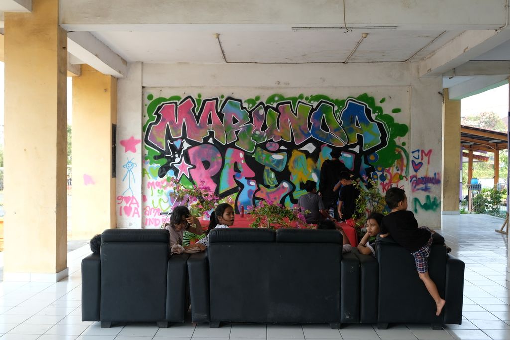 Sejumlah anak melihat artis yang sedang membuat mural di kompleks Rusun Marunda, Cilincing, Jakarta Utara, Sabtu (22/10/2022).