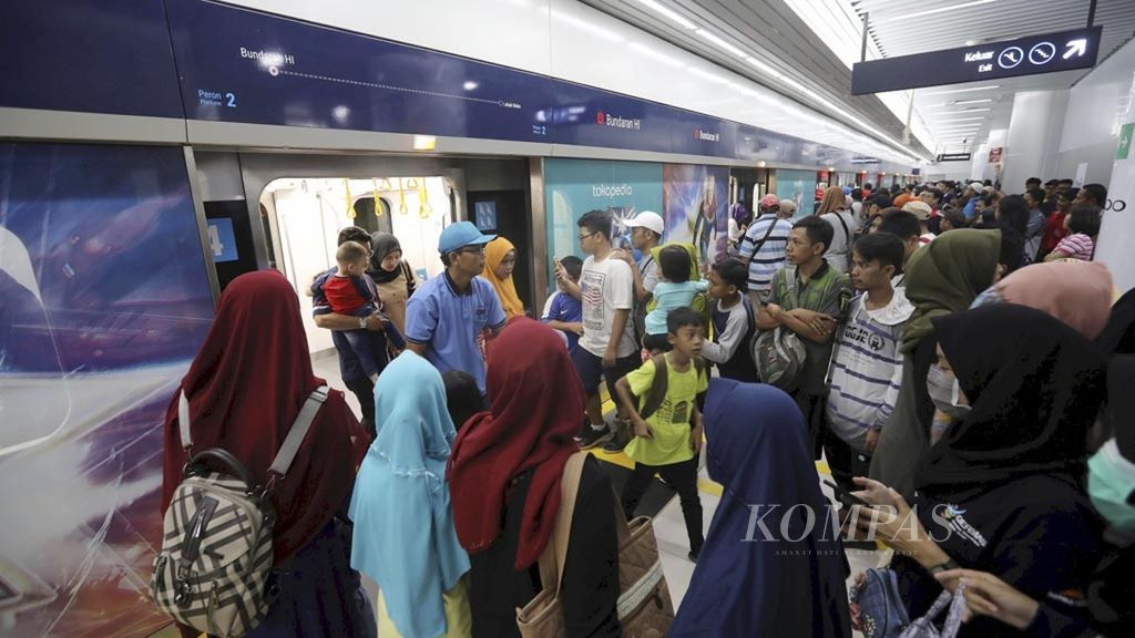 Residents queue to board the Ratangan Moda Raya Terpadu (MRT) train at the Bundaran HI MRT Station, Jakarta, Sunday (3/24/2019).