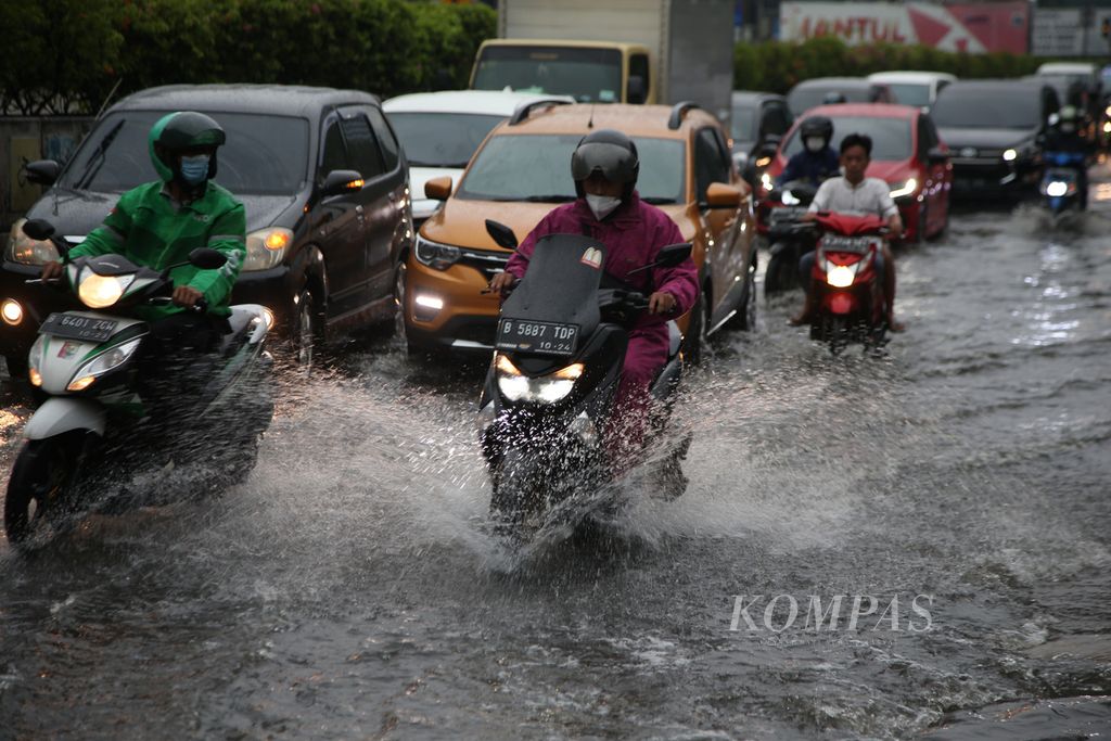 Pengendara menembus genangan air saat hujan deras mengguyur kawasan Gandaria, Jakarta, Jumat (22/4/2022). 