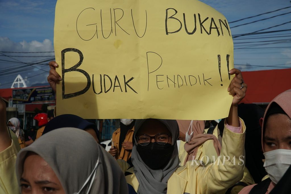 Students hold cardboard signs with criticisms during a rally commemorating National Teacher's Day on Sudirman Street in front of the West Sumatra Governor's Office in Padang, West Sumatra, on Thursday (25/11/2021). The students demanded that the central and local governments pay attention to the fate of teachers, especially non-permanent teachers, who are far from being prosperous.