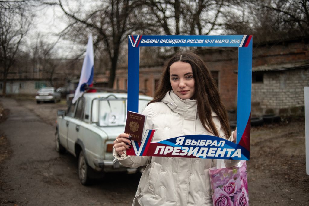 Seorang wanita berpose setelah memberikan suaranya di tempat pemungutan suara keliling selama pemungutan suara awal dalam pemilihan presiden Rusia di Donetsk, Ukraina, yang dikuasai Rusia, Kamis (14/3/2024). 