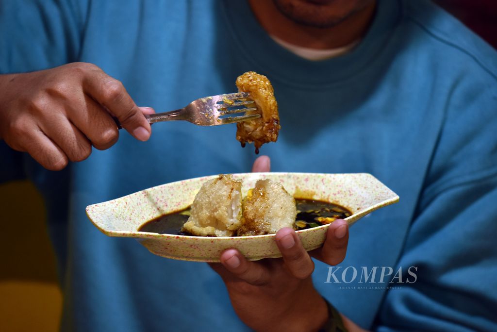 Visitors are preparing to savor the large egg pempek or submarine sandwiches on Depaten Lama Street, 27 Ilir Village, Ilir Barat II District, Palembang, South Sumatra, on Tuesday (12/12/2023).