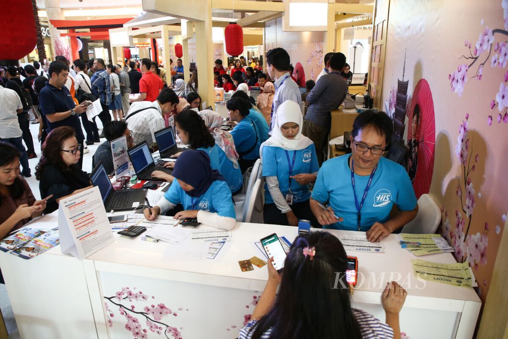 Petugas melayani pengunjung dalam BNI Japan Airlines Travel & Expo di Kota Kasablanka Mall, Jakarta, Jumat (19/7/2019). 