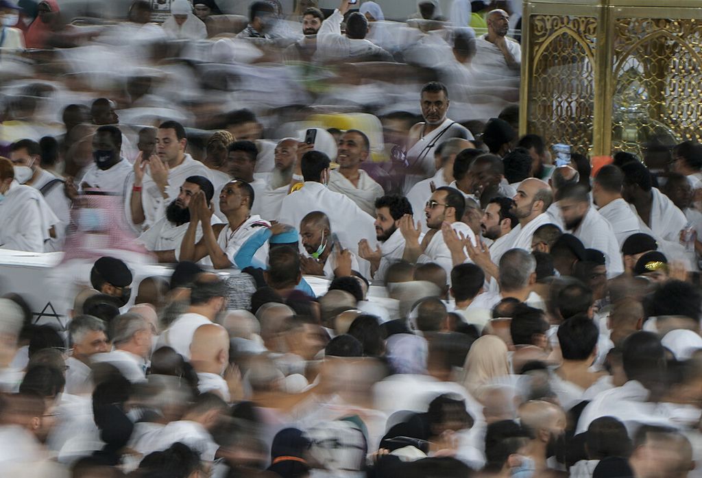 In this photo taken with low shutter speed, Muslim pilgrims pray as others circumambulate around the Kaaba, the cubic building at the Grand Mosque, in Mecca, Saudi Arabia, Wednesday, July 6, 2022. Muslim pilgrims are converging on Saudi Arabia's holy city of Mecca for the largest hajj since the coronavirus pandemic severely curtailed access to one of Islam's five pillars. 