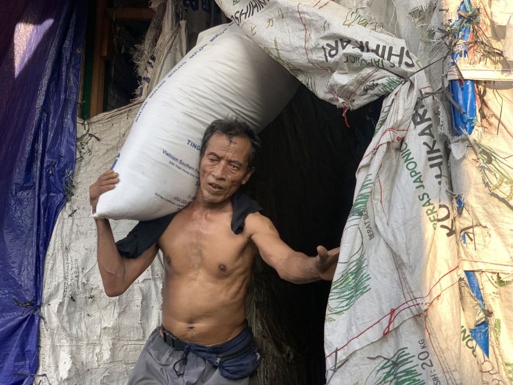 Maming (62), a porter carrying a sack of rice at the Cipinang Rice Main Market, Wednesday (8/3/2023).