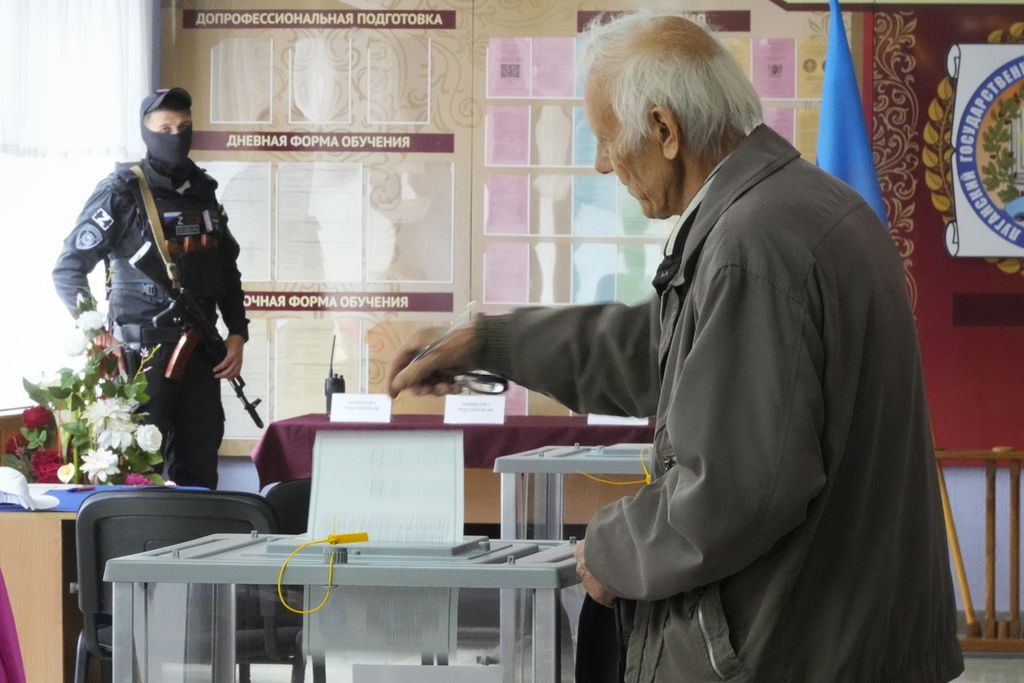 Seorang pria memasukkan kertas suara dalam referendum di Luhansk, wilayah yang dikontrol Republik Rakyat Luhansk, Ukraina timur, Selasa (27/9/2022). 
