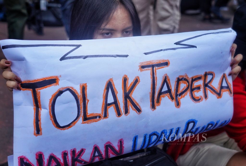 Buruh membawa poster saat bersama massa dari berbagai elemen serikat buruh melakukan demonstrasi menolak program Tabungan Perumahan Rakyat atau Tapera di kawasan Patung Arjuna Wijaya, Jakarta, Kamis (6/6/2024).  