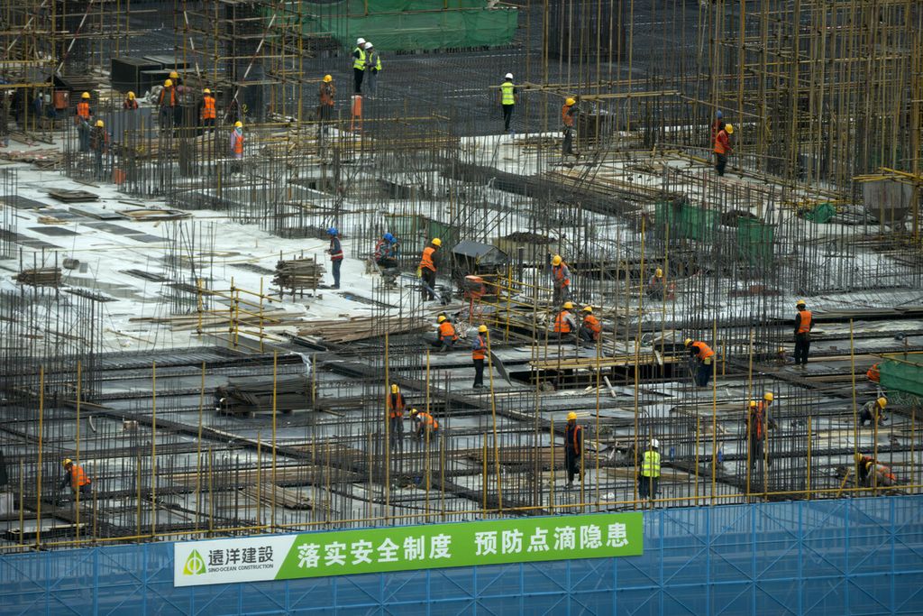 Pekerja konstruksi bekerja di sebuah lokasi pembangunan di pusat distrik bisnis di Beijing, China, 13 Juni 2023. 