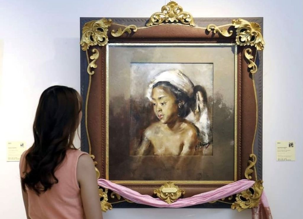 Seorang pengunjung mengamati lukisan berjudul ”Portrait of a Balinese Girl” karya Antonio Blanco dalam pameran lelang Masterpiece, Jakarta, April 2023.