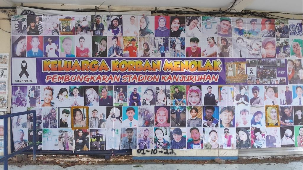 Deretan foto korban Tragedi Kanjuruhan terpampang di dekat pintu 13 Stadion Kanjuruhan, di Kabupaten Malang, Jawa Timur, sebagaimana terlihat pada Jumat (14/7/2023). Tertulis kata Keluarga Korban Menolak Pembongkaran Stadion Kanjuruhan. 