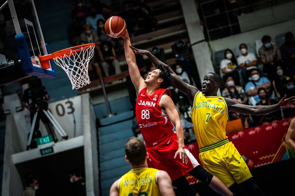Pemain Jepang, Tenketsu Harimoto (jersei merah), mencoba melakukan <i>dunk </i>di tengah kawalan <i>center</i> Australia, Thon Maker, dalam laga perempat final Piala Asia FIBA 2022 di Istora Senayan, Jakarta, Kamis (21/7/2022). Jepang kalah dari Australia, 85-99.