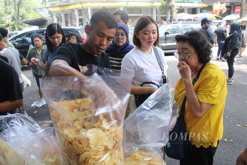 Penjual mengambil makanan ringan yang disebut kentang manohara yang dijual di Jalan Kemuning, Kota Bandung, Jawa Barat, Jumat (12/4/2024). Makanan ringan yang terbuat dari kentang goreng ini cukup diminati para pembeli.