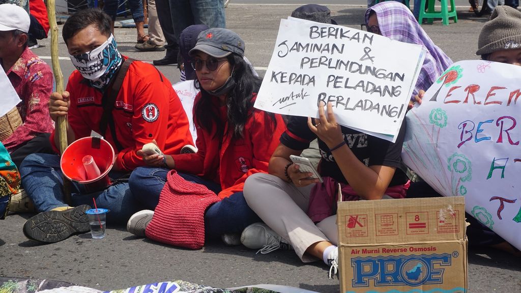 ILUSTRASI. Para peserta aksi dari Solidaritas Peladang Tradisional Kalimantan Tengah duduk di depan kantor Polda Kalteng, Selasa (10/12/2019). Mereka menuntut aparat keamanan untuk membebaskan peladang-peladang yang ditangkap karena membakar.