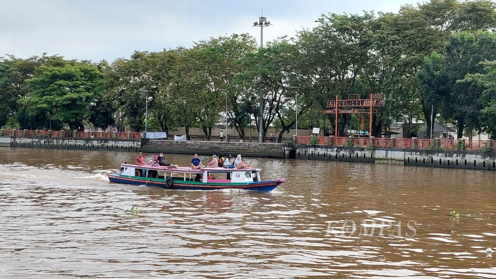 Perahu bermotor atau <i>kelotok </i>melintas di Sungai Martapura, sekitar kawasan wisata siring pada hari pertama 2022 di Kota Banjarmasin, Kalimantan Selatan, Sabtu (1/1/2022).