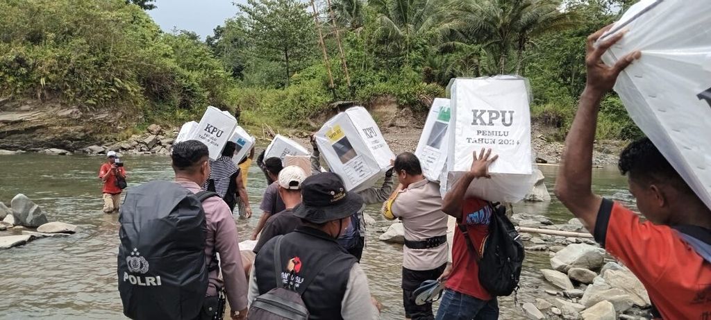Warga dan petugas dari Polri, KPU, Bawaslu daerah mengangkut logistik menyeberangi Sungai Nui, Seram Bagian Barat, Maluku Senin, (12/2/2024).