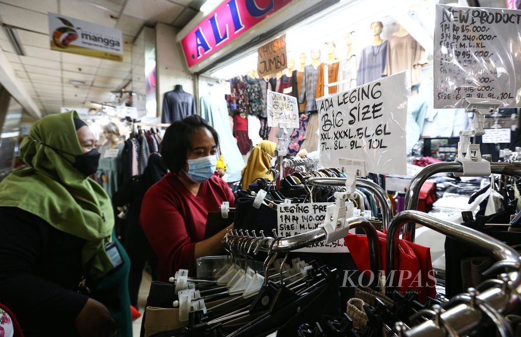 Pramuniaga membantu pengunjung melncari ukuran pakaian di gerai Alice yang khusus menjual pakaian ukuran besar di Blok A Pasar Tanah Abang, Jakarta Pusat, Rabu (26/1/2022).