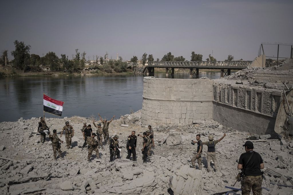Pasukan Unit Khusus Irak bersuka cita merayakan keberhasilan mencapai tepi Sungai Tigris di wilayah Kota Tua Mosul, Irak utara, yang sebelumnya dikuasai milisi Negara Islam di Irak dan Suriah (NIIS) dalam foto bertanggal 9 Juli 2017. Kemunculan NIIS di Irak tidak terlepas dari kegagalan negeri itu mengadopsi budaya politik demokrasi modern pascainvasi pasukan AS yang menggulingkan rezim Saddam Hussein.