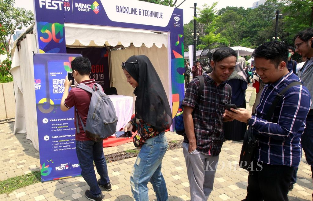Pencari kerja antre untuk dapat giliran memindai kode tautan layanan kerja di bursa kerja yang diadakan di Job Fair MNC Festival, Jakarta, 3 November 2019. 