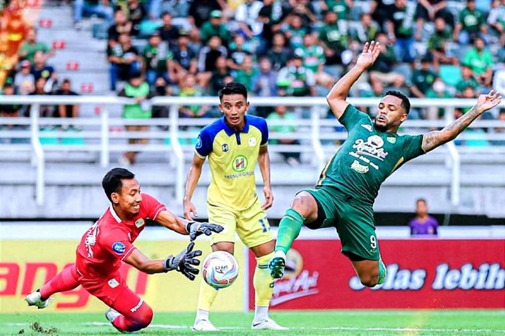 Pemain Persebaya, Paulo Victor (kanan), berebut bola dengan penjaga gawang Barito Putera, Ega Rizky (kiri), saat pertandingan pekan kedua Liga 1 Indonesia musim 2023-2024, Sabtu (8/7/2023) sore.