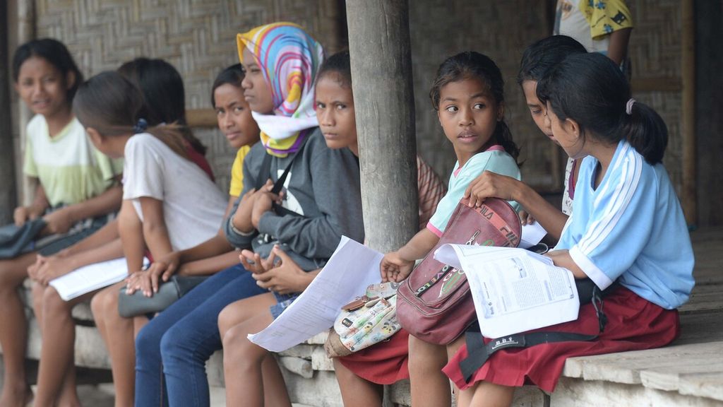 Para murid SD Negeri Watumbaka, Kecamatan Pandawai, Kabupaten Sumba Timur, Nusa Tenggara Timur, membaca buku saat menunggu kedatangan guru mereka di rumah warga di Desa Watumbaka, Pandawai, Sumba Timur, Rabu (3/2/2021). 