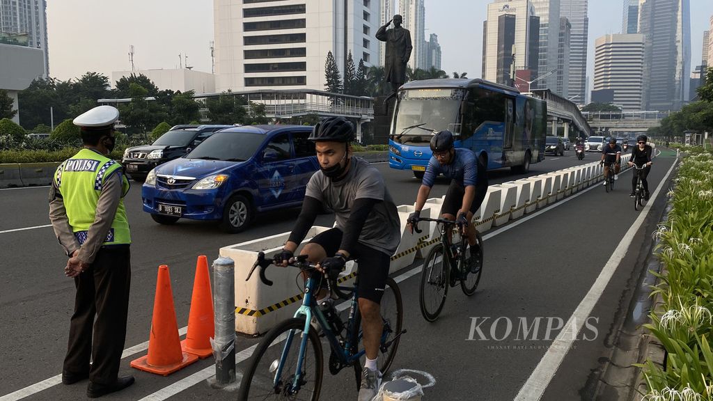 Petugas kepolisian bersama dinas perhubungan (dishub) berjaga di jalur sepeda di Jalan Jenderal Sudirman, Jakarta, Rabu (2/6/2021). Hari itu sejumlah petugas kepolisian bersama dishub melakukan penertiban terhadap pesepeda di Jalan Thamrin-Sudirman untuk melaju di jalur sepeda.