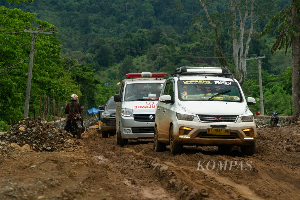 Kendaraan umum hingga ambulans bersusah payah melewati jalan berlumpur di Oheo, Konawe Utara, Sulawesi Tenggara, Sabtu (4/12/2021).