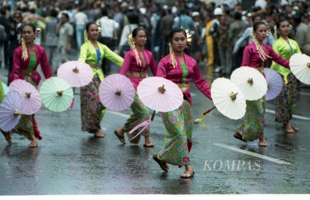 Para Mojang Priangan membawakan Tarian Cancala Pratita di bawah guyuran hujan, Sabtu (5/9/1992). Tarian yang digelar di Jalan Asia Afrika, Bandung, itu untuk menyambut kedatangan Delegasi KTT X Gerakan Nonblok.